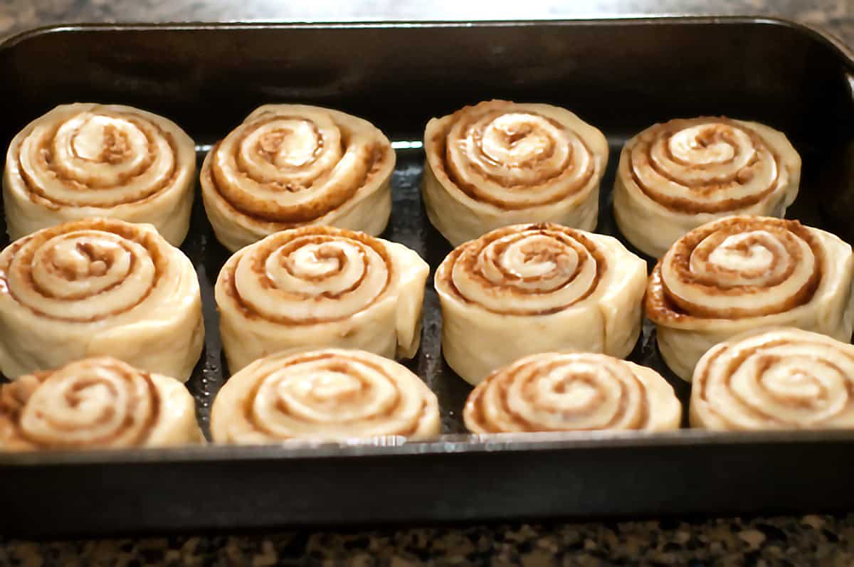 Cinnamon Rolls with Cream Cheese Icing Prepared buns in a baking pan.