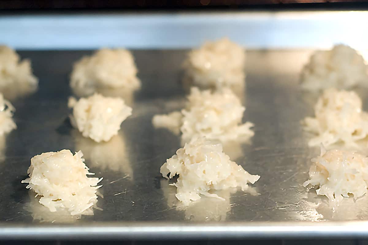 Dollops of coconut macaroon mixture on a baking sheet.