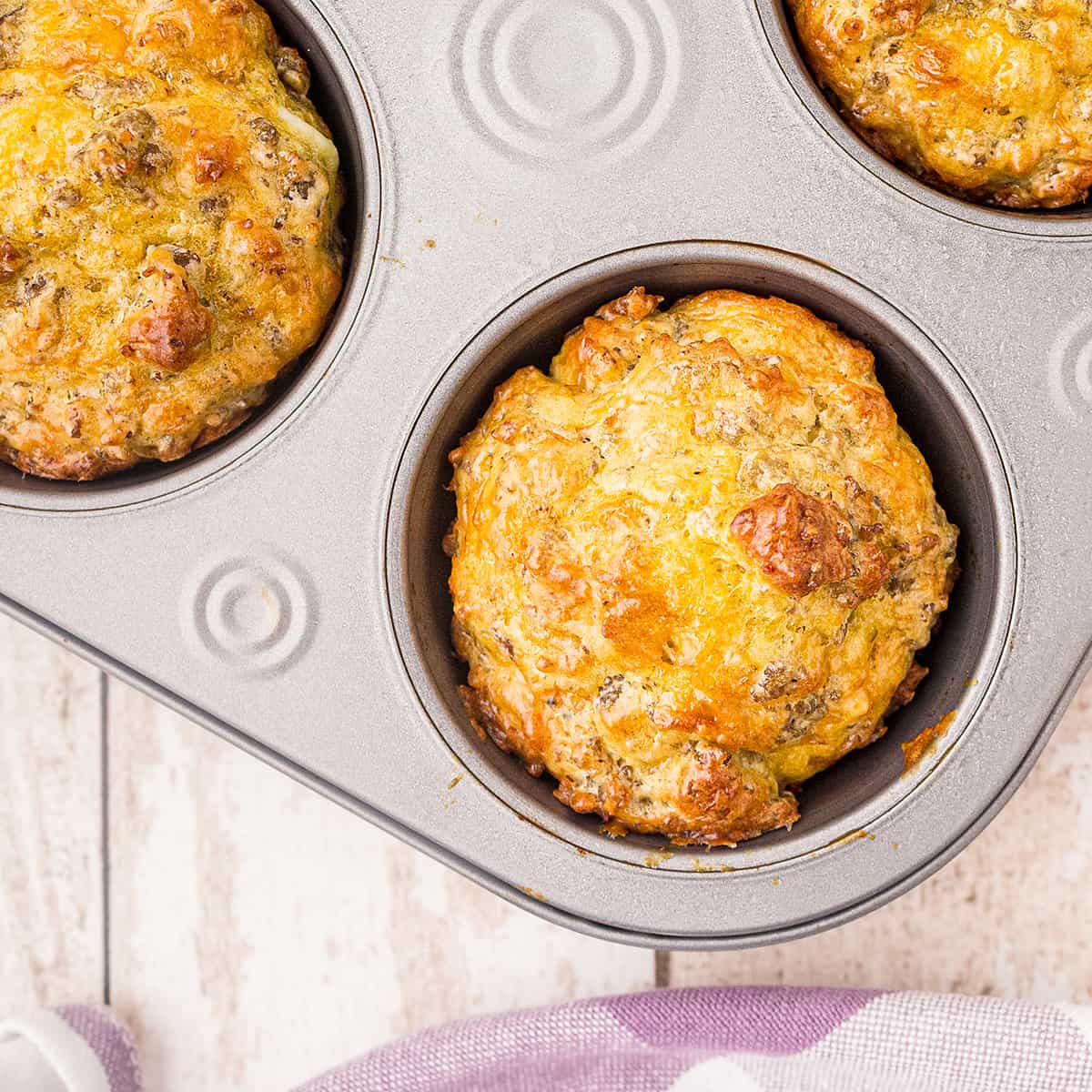 Golden brown cooked Easy Sausage Muffins in a muffin baking pan.