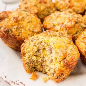 Easy Sausage Muffins on a serving plate; one muffins with a bite taken.