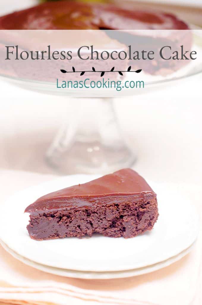 A slice of flourless chocolate cake with chocolate ganache on a serving plate.