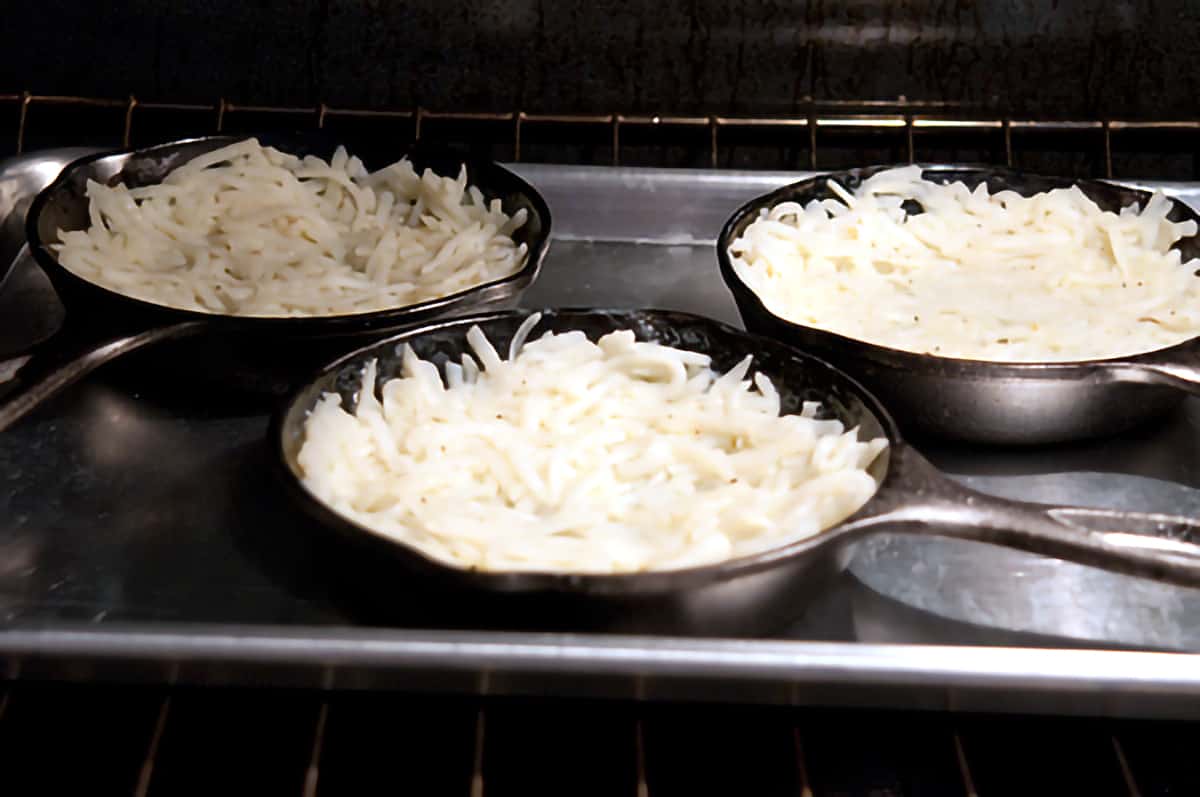 Individual skillets containing hash brown, butter, and egg white mixture.