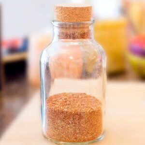 Glass jar filled with homemade taco seasoning mix.