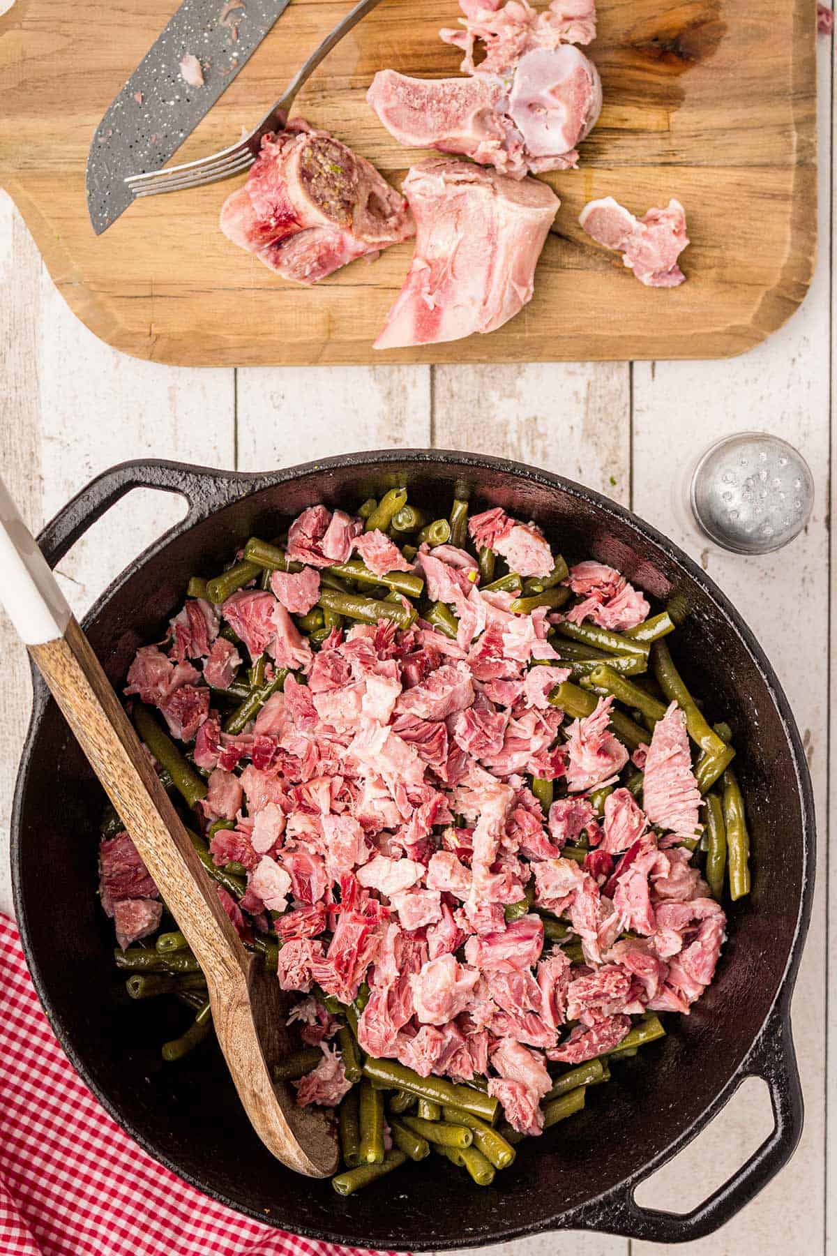 Shredding the ham hock meat to add back to the beans