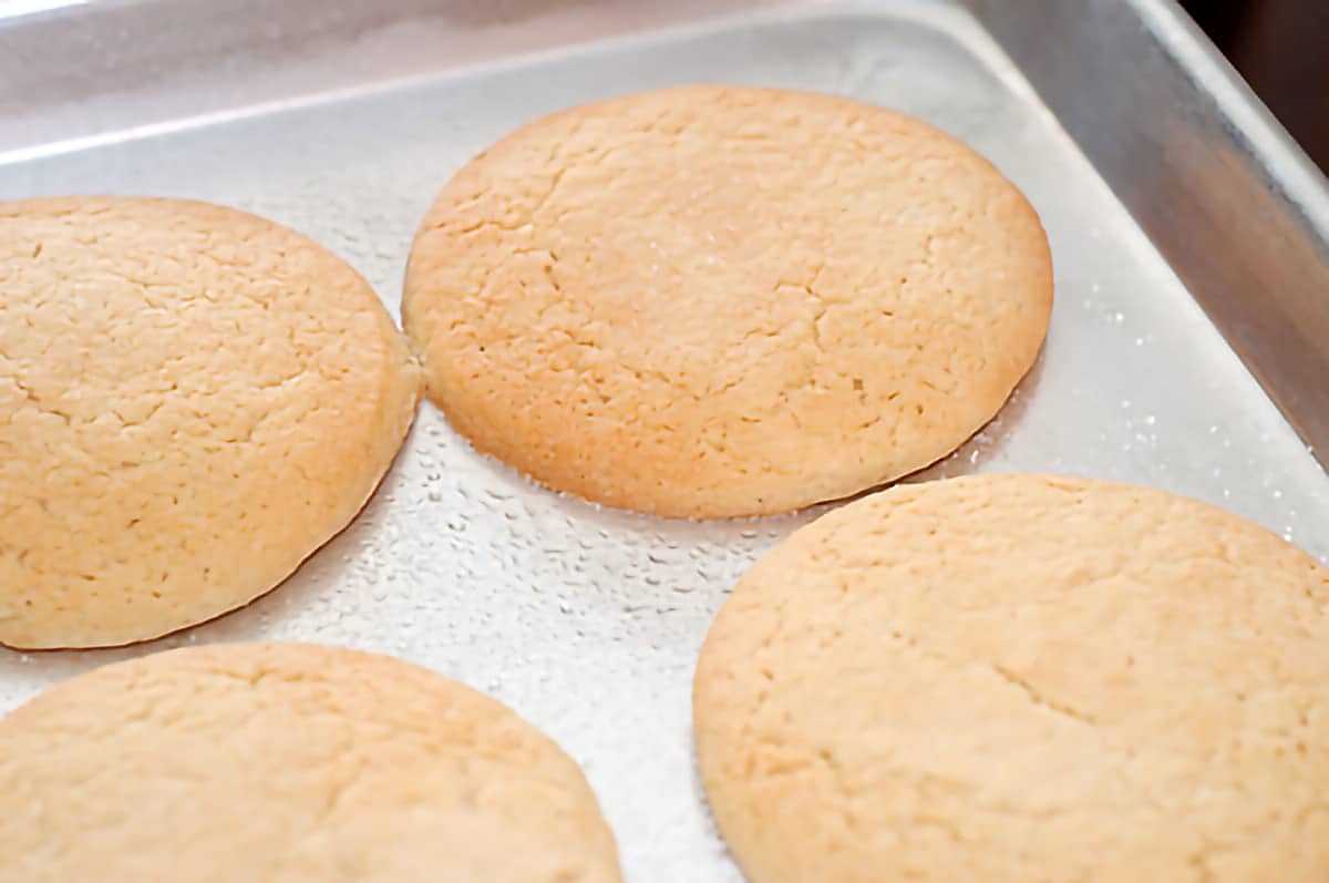 Cooked tea cakes on a baking sheet.