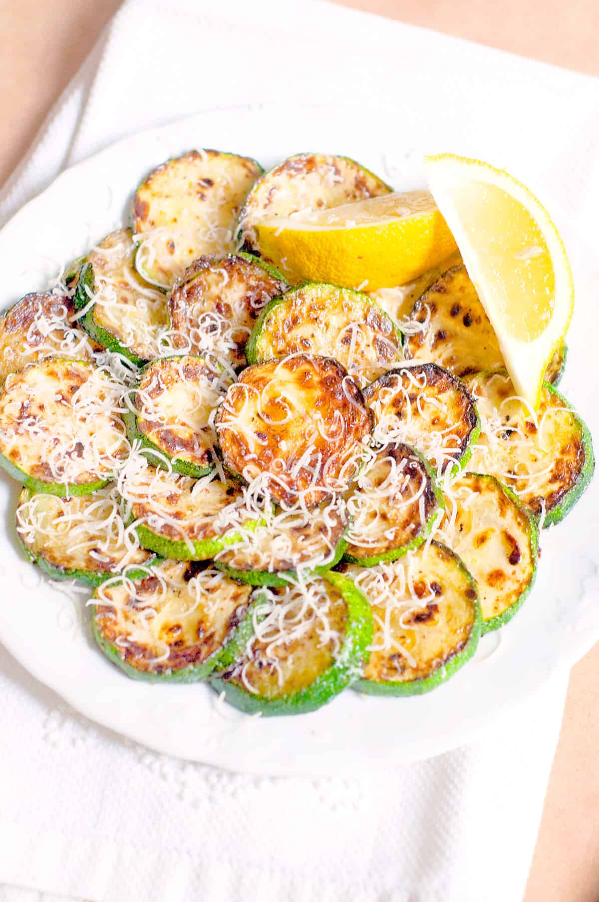 Pan Fried Zucchini with Parmesan and Lemon arranged on a serving plate.