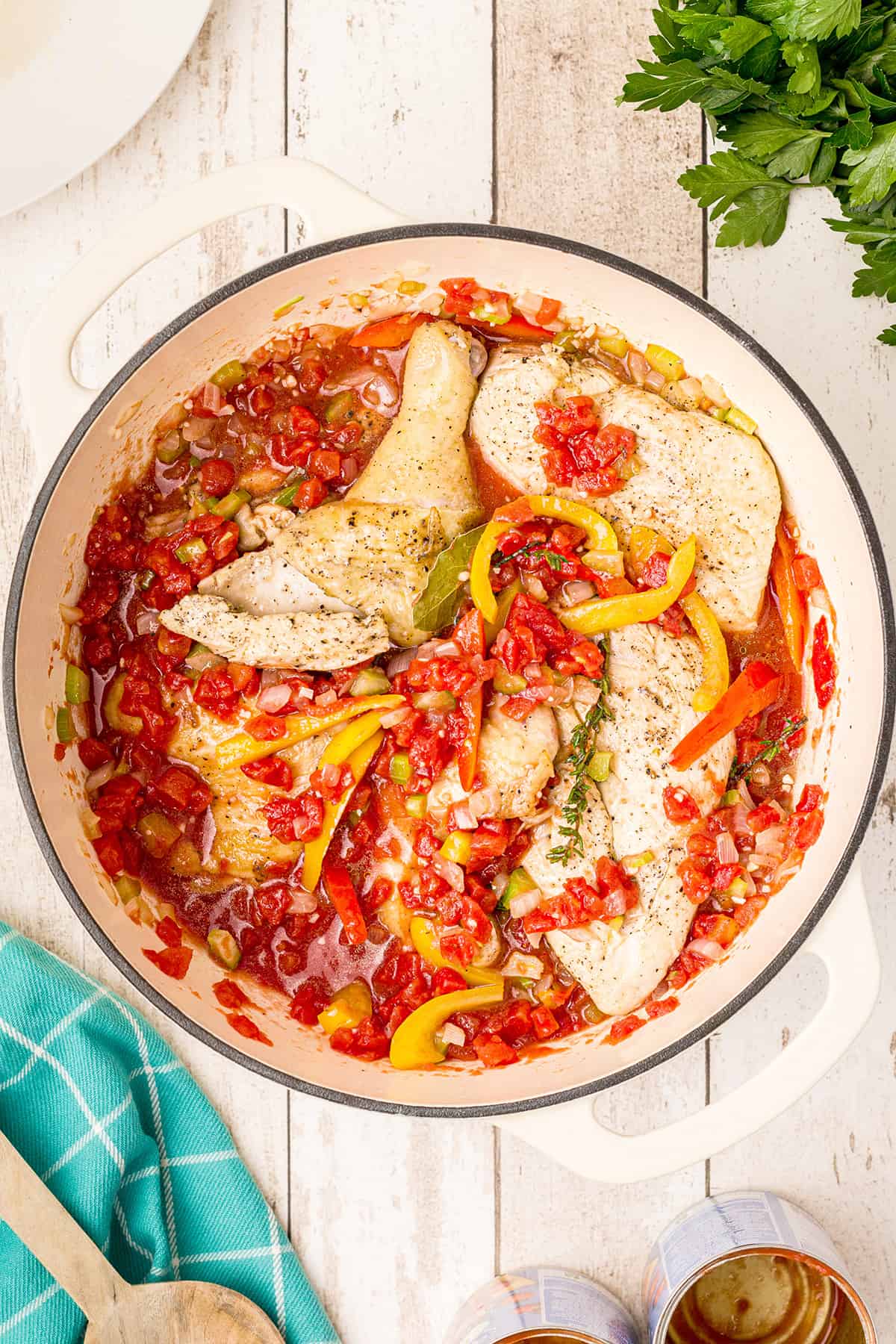 Browned chicken added to tomato and veggie sauce in Dutch oven.