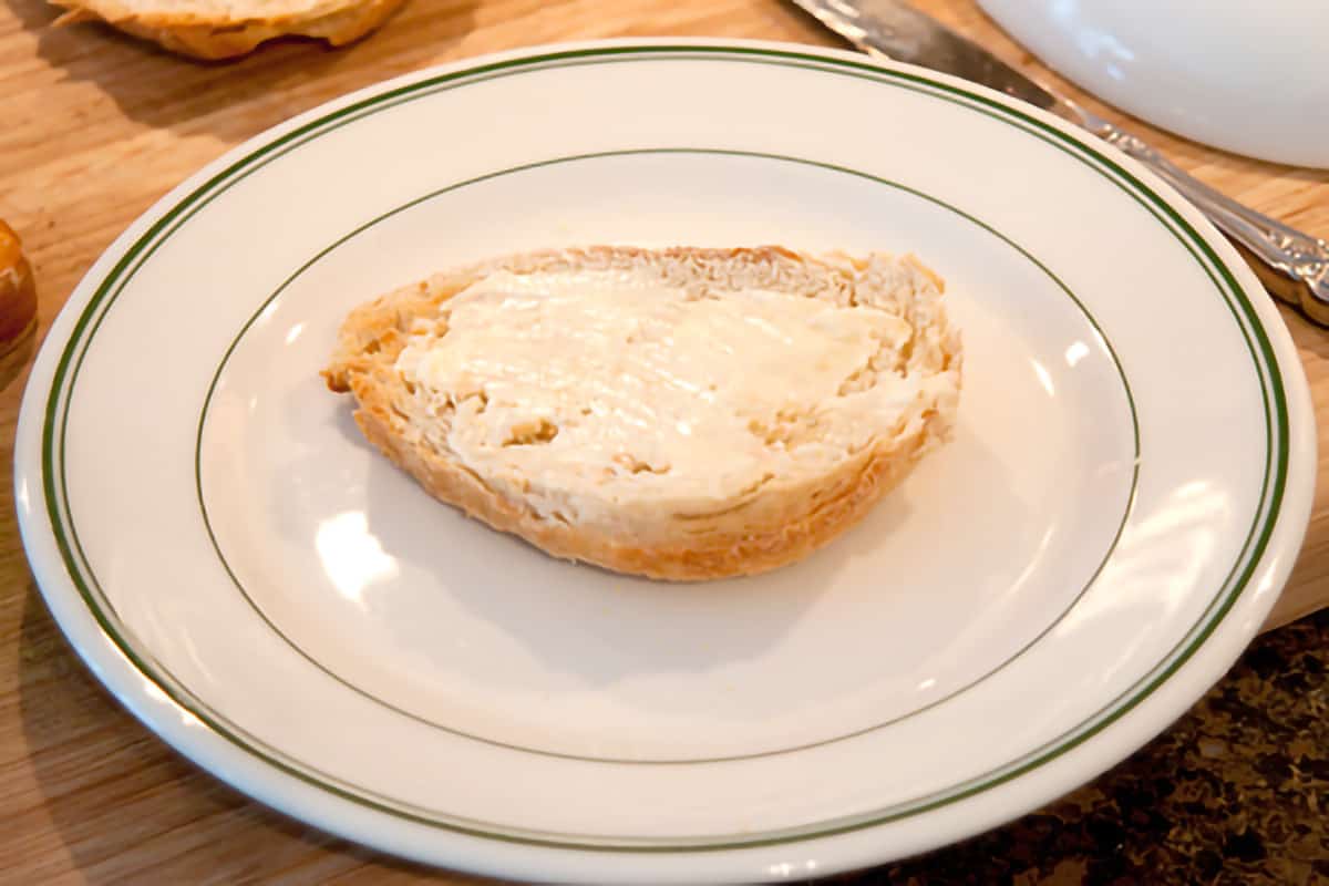 A piece of buttered toast on a serving plate.