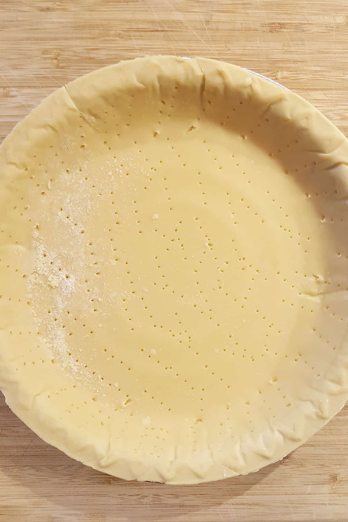 Thawed pie crust that has been pricked all over the bottom with a fork.