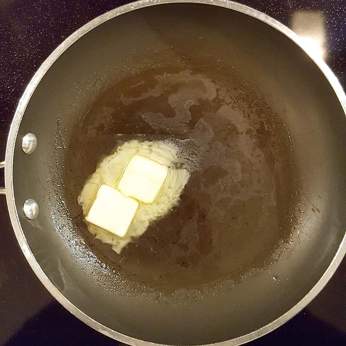Butter and oil melting in a skillet.
