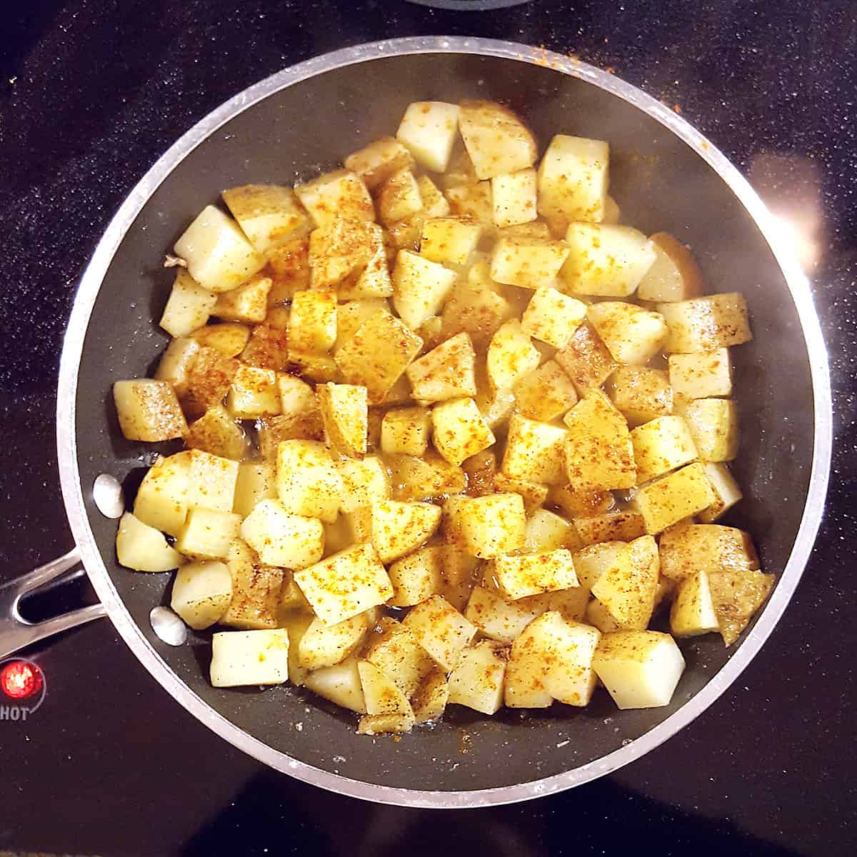 Potatoes cooking in a skillet.