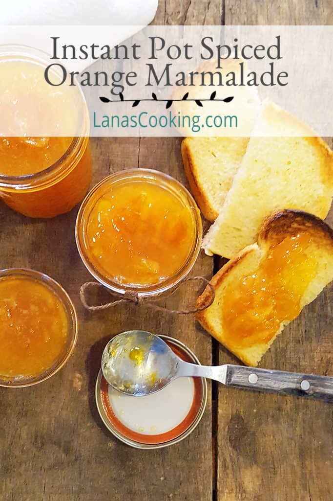 Jars of spiced orange marmalade with a spoon and toasted bread.