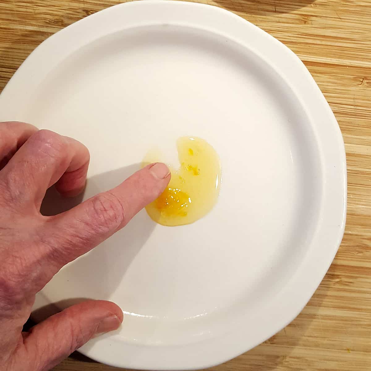 White plate with a dollop of marmalade (cold plate test for jellying point).