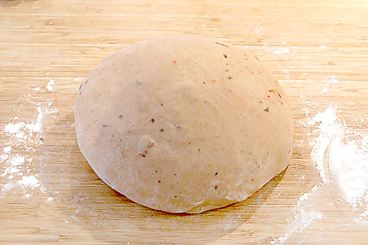 Kneaded dough on a wooden cutting board.