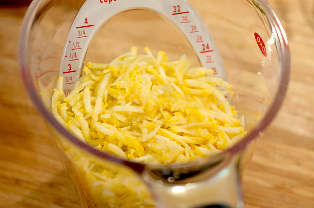 Grated squash in a measuring cup.
