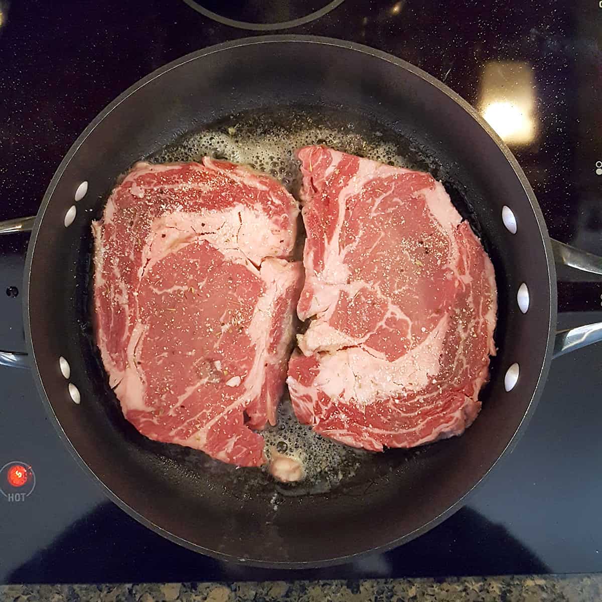Two steaks in a skillet.