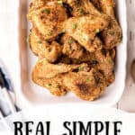 Finished fried chicken on a white serving platter.
