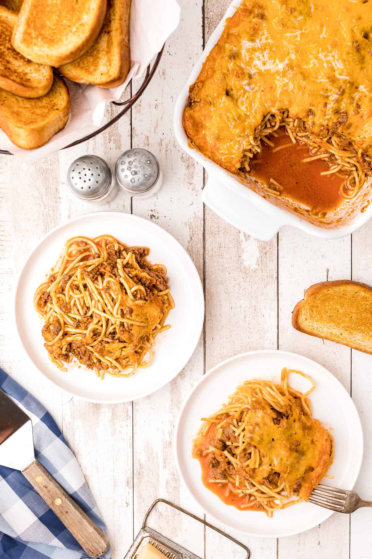 Two small serving plates with a portion of baked spaghetti. 