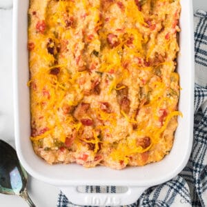 Cheessy tomato grits in a white baking dish.