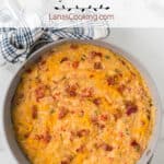 Cheessy tomato grits in a skillet.