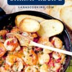 Shrimp cooked with cilantro and lime in a skillet, garnished with herbs, served with toasted bread slices.