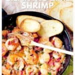 Skillet of cilantro lime shrimp with toasted bread slices and a wooden spoon, ready to serve.