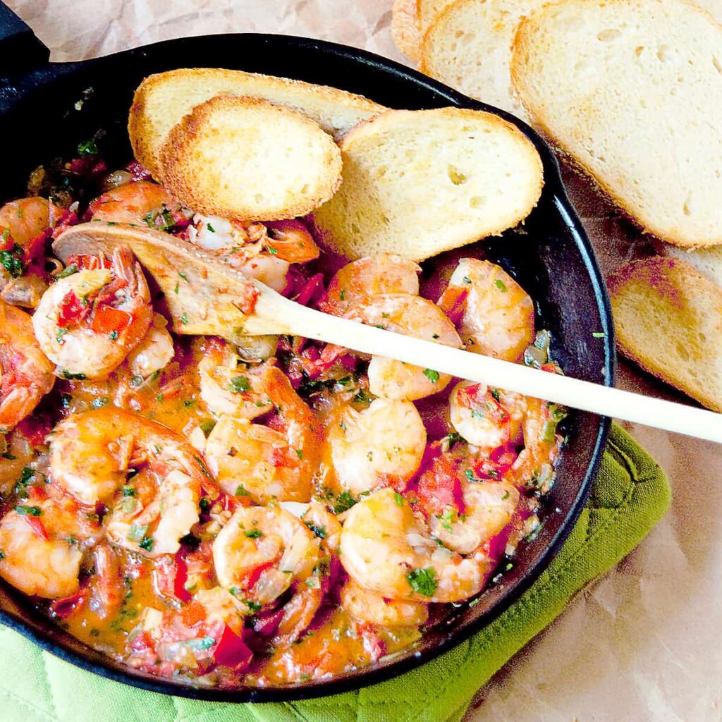 Cilantro Lime Shrimp in a cast iron skillet with garlic bread on the side.