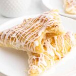 Peach turnovers on a white serving plate.
