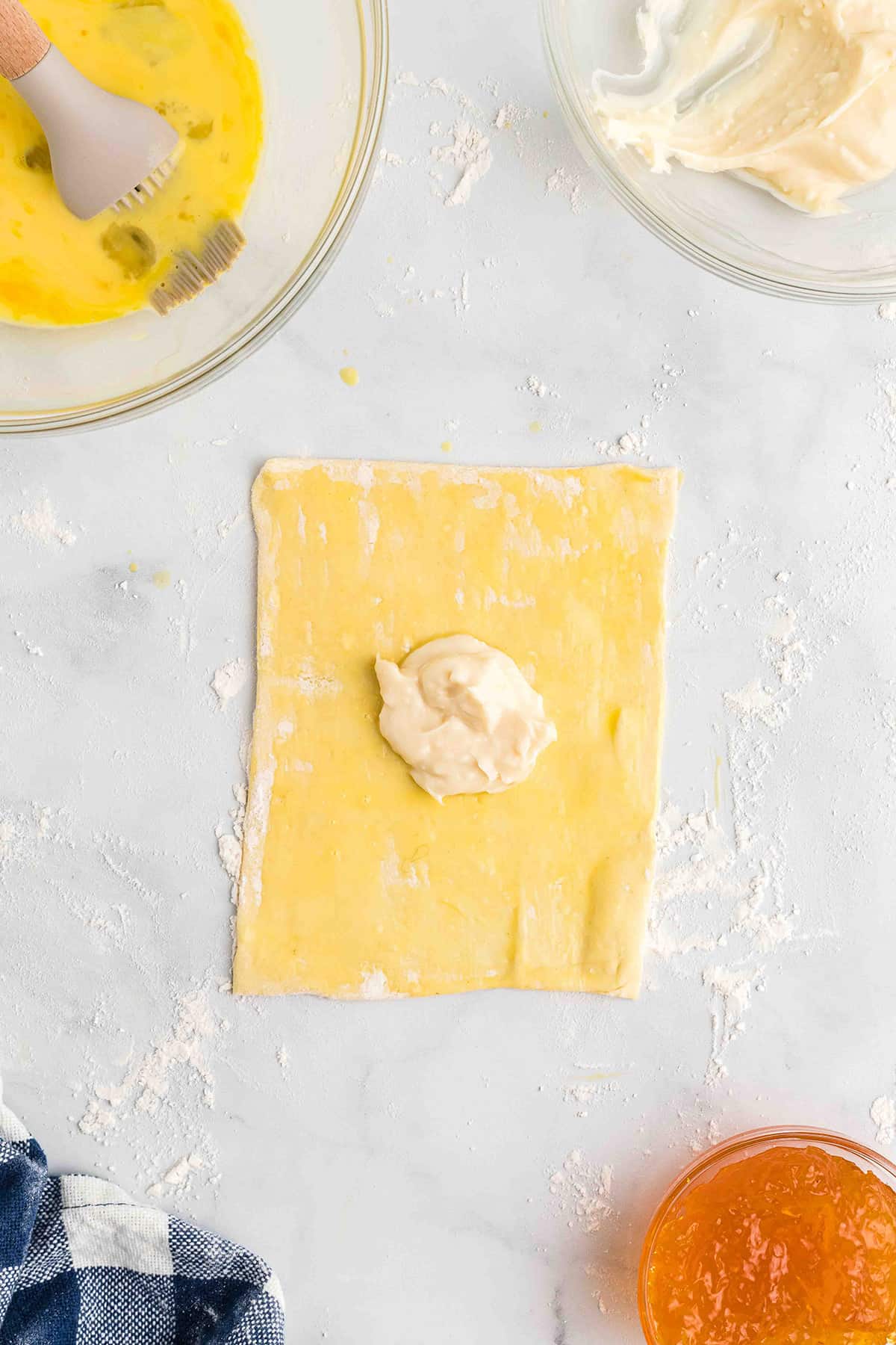 A square of puff pastry topped with cream cheese filling.