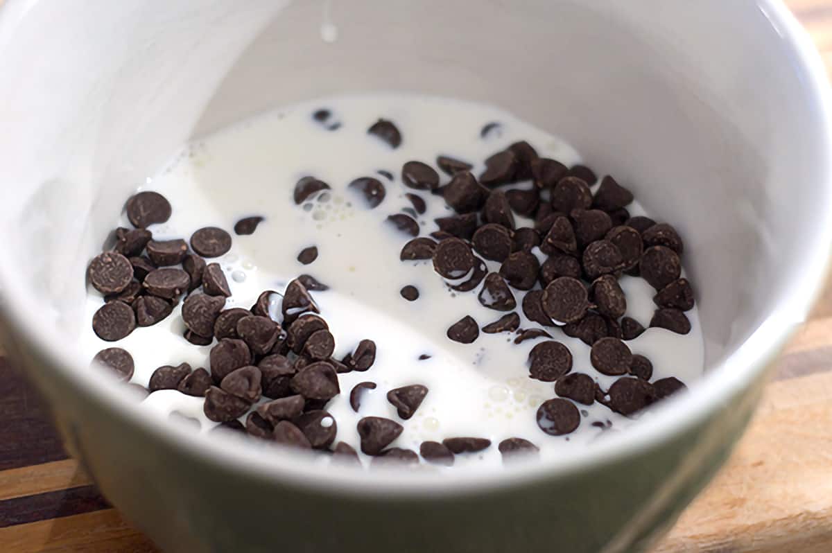 Chocolate chips and heavy whipping cream in a microwave safe mixing bowl.