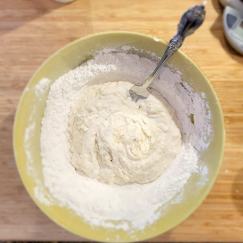 Dough being mixed inside a mixing bowl.