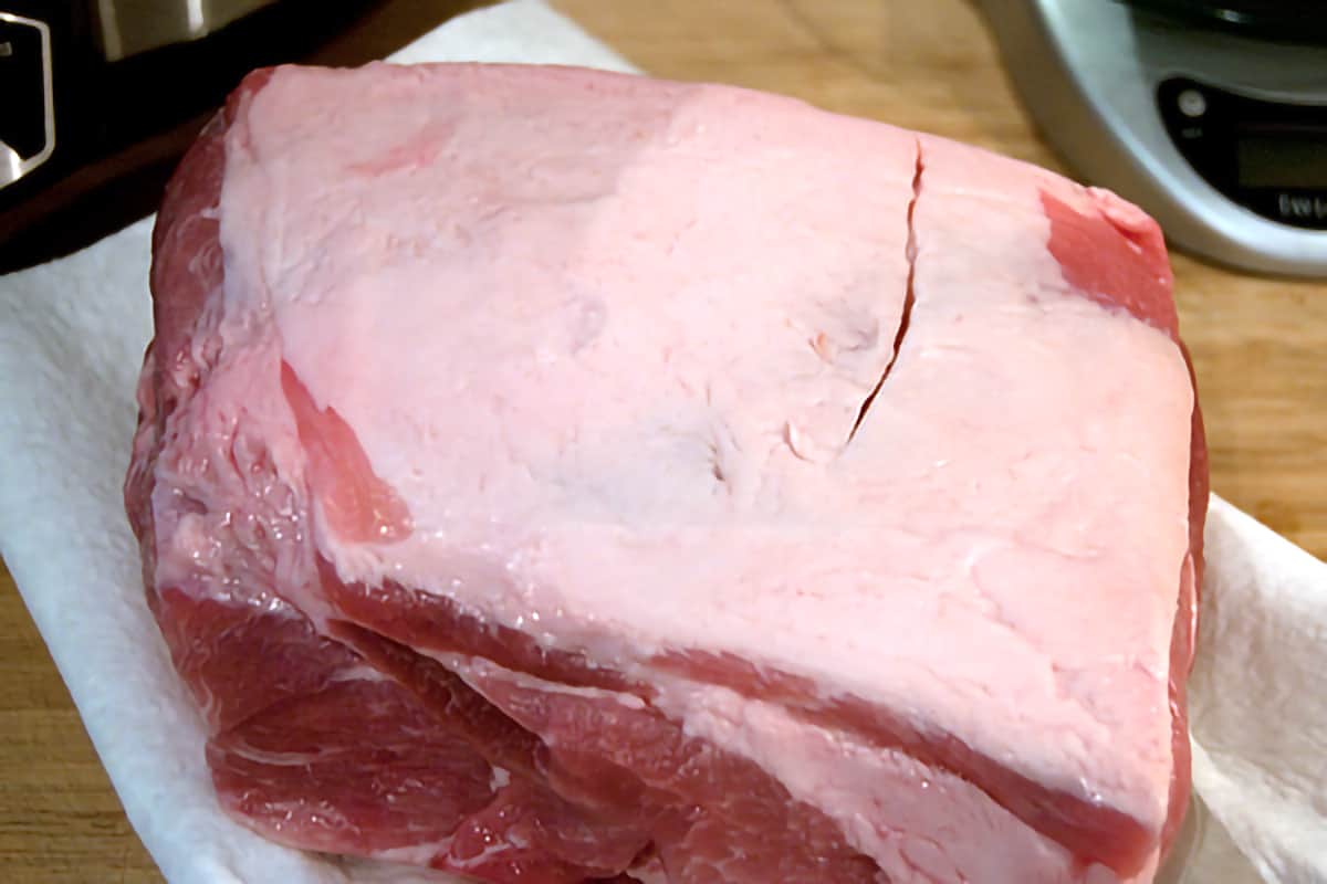 Four pound pork shoulder roast sitting on paper towels on a cutting board.