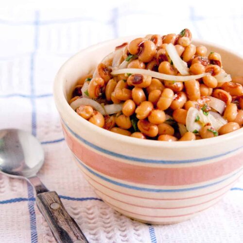Black Eyed Pea Salad in a vintage serving bowl set on a kitchen towel.