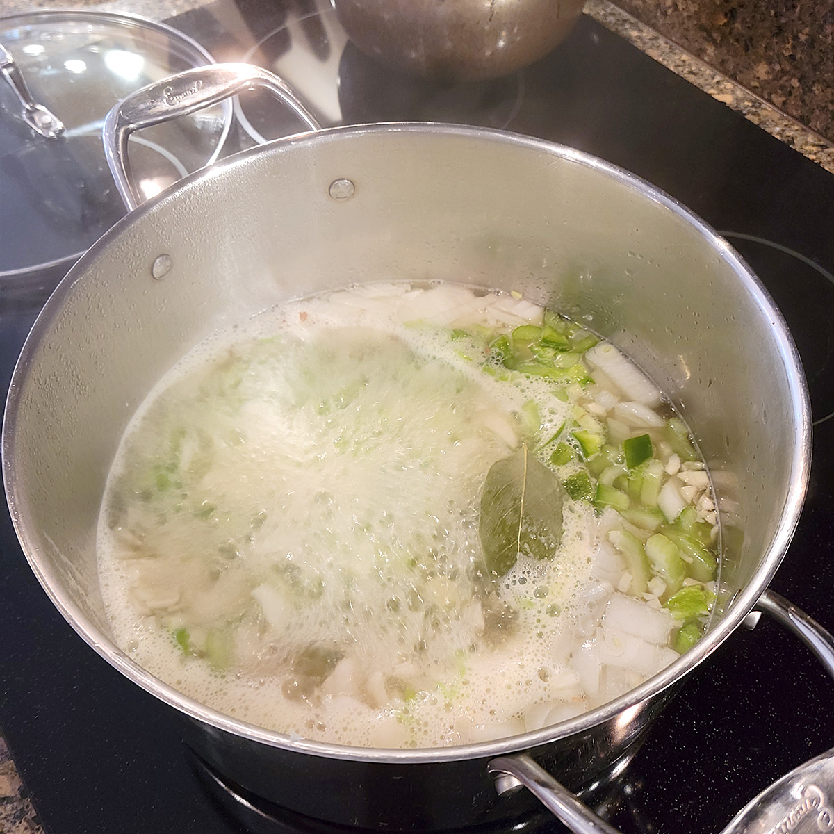 Stock and vegetables boiling in a large pot.