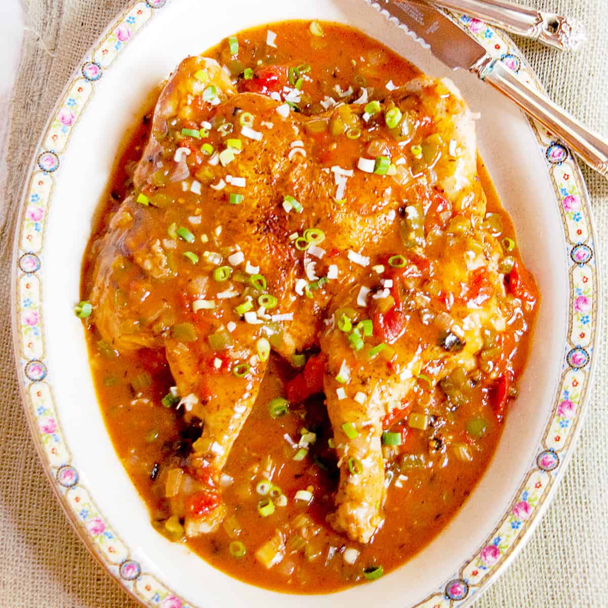 Creole Style Smothered Chicken presented on a large serving platter.