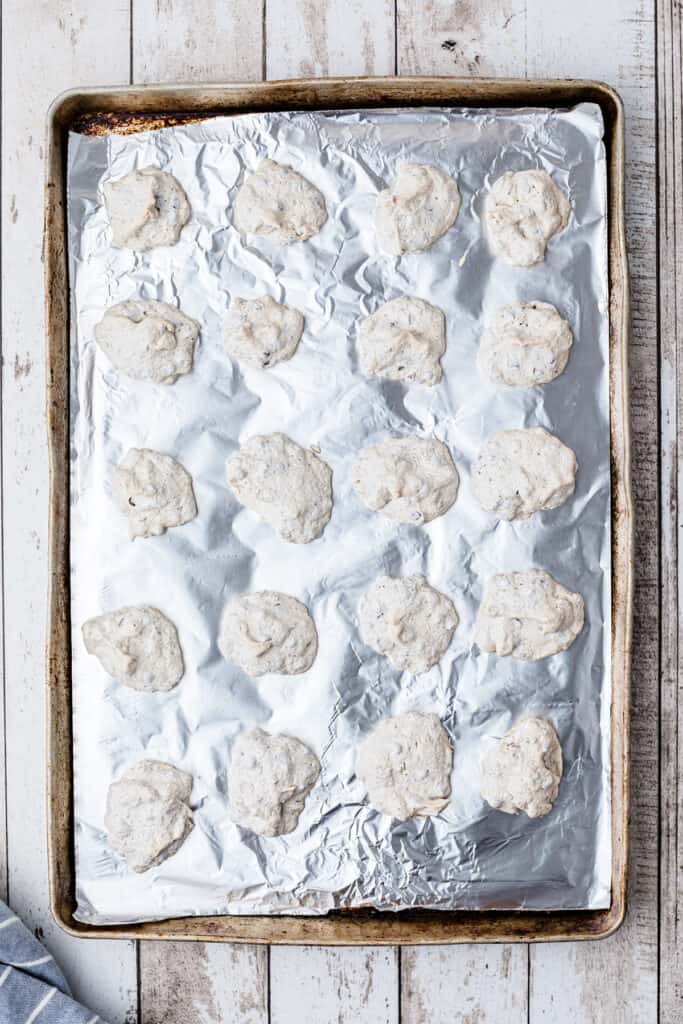 Full baking sheet of meringues ready for oven.