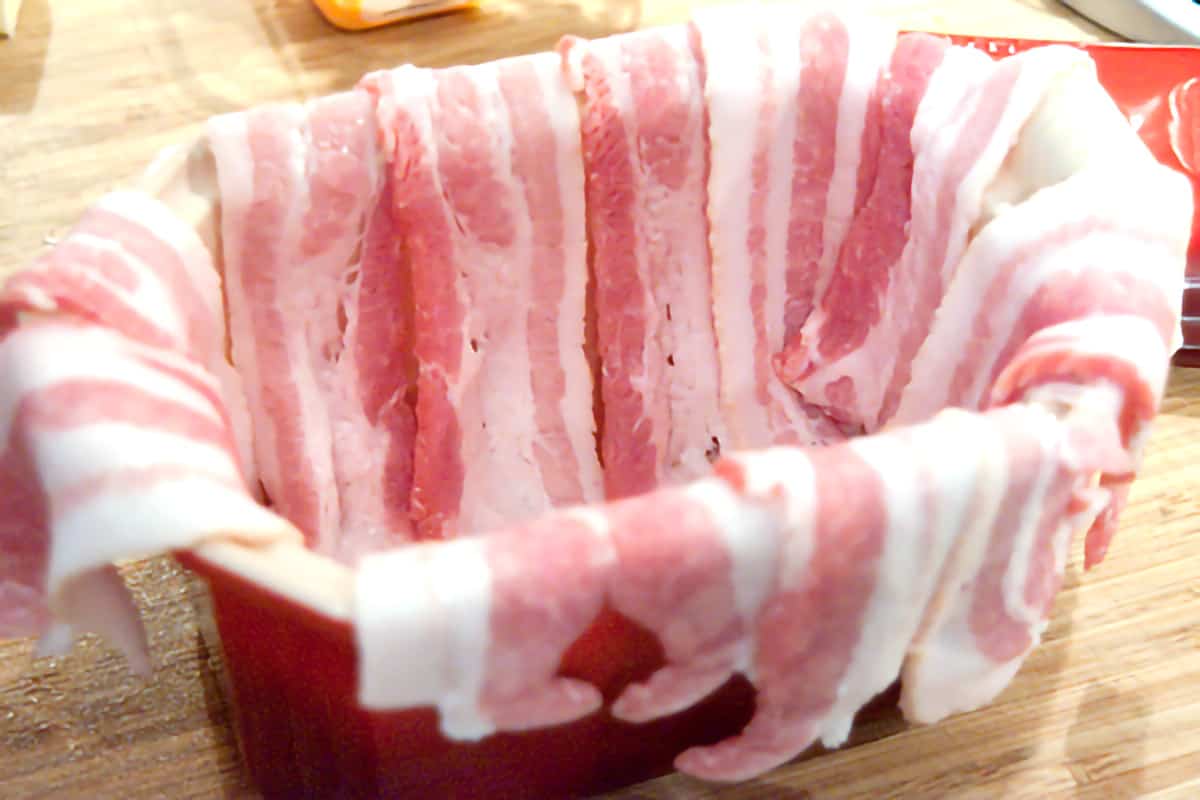 A terrine lined with bacon strips.