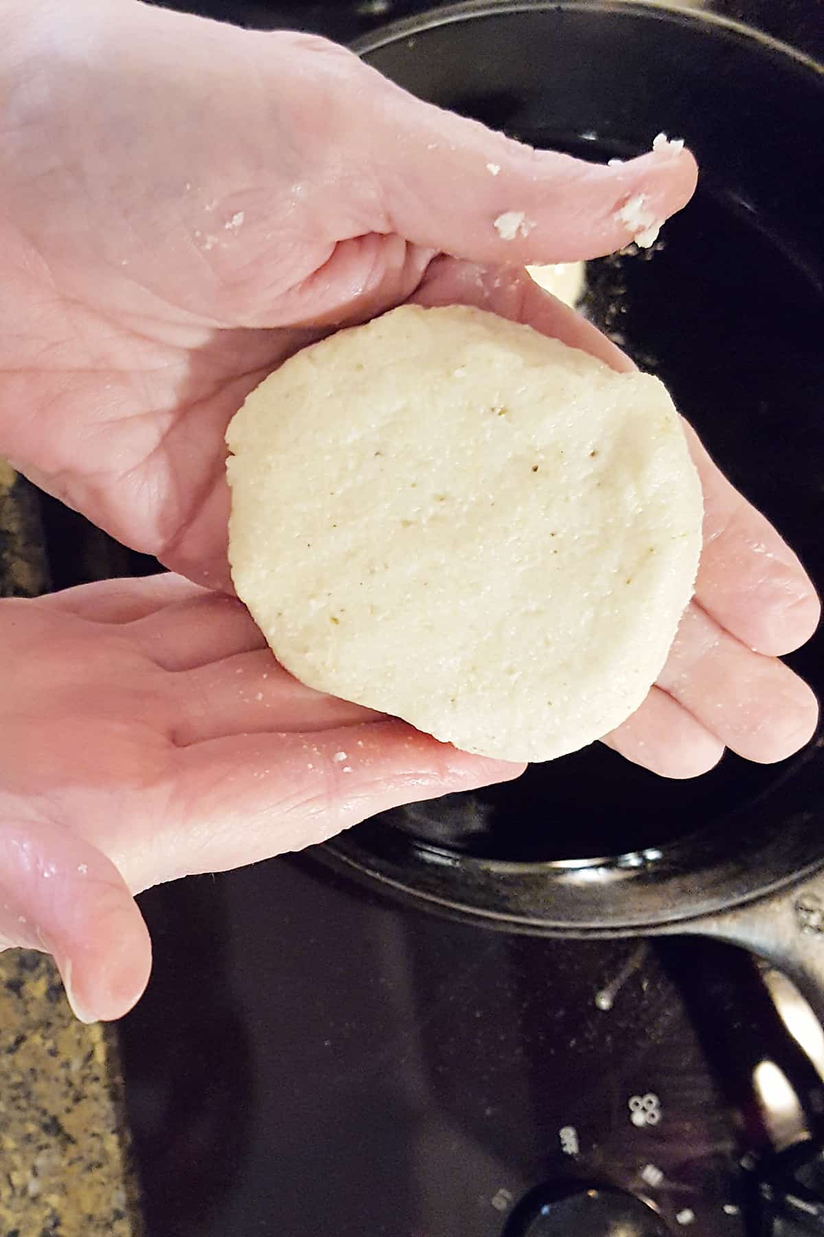 Cornmeal patty formed by hand.