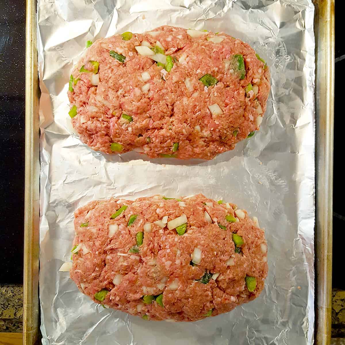 Mixture shaped into two loaves on a baking sheet lined with foil.