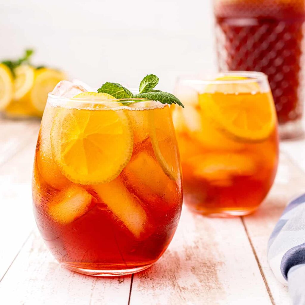 A glass of southern iced sweet tea with lemon and mint.
