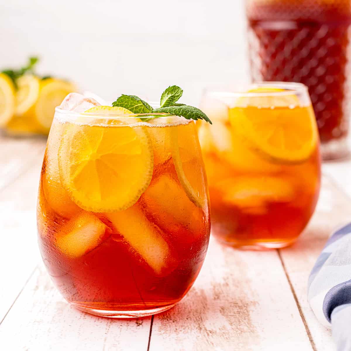 A glass of southern iced sweet tea with lemon and mint.