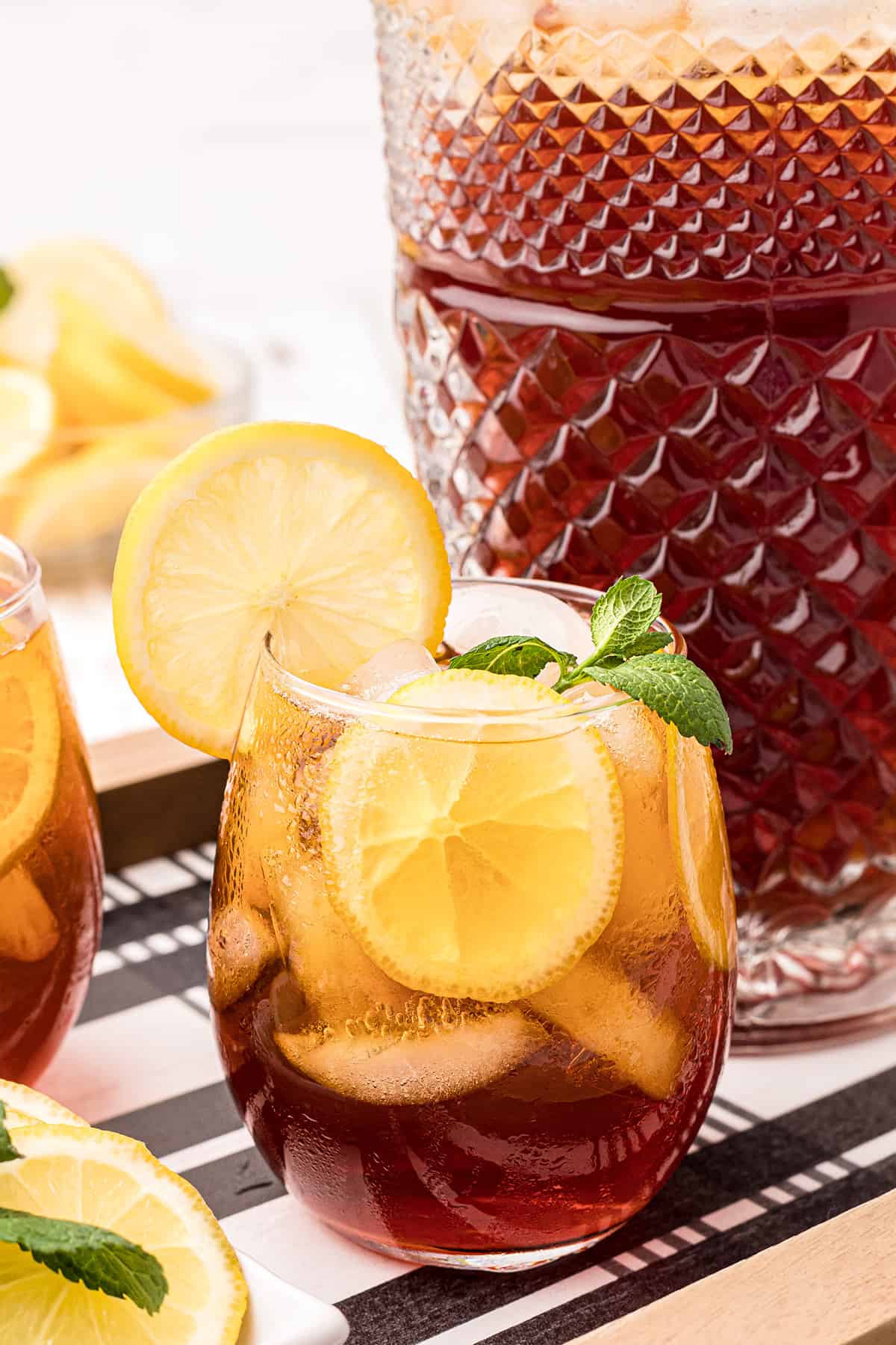 A glass of southern iced sweet tea with lemon and mint on a serving tray.