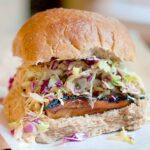 Asian barbecue sandwich with coleslaw on a bun.