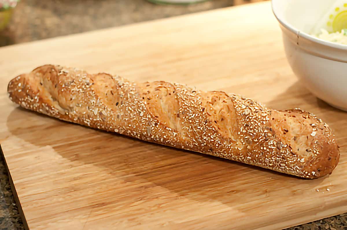 Loaf on whole grain Italian bread on a cutting board.