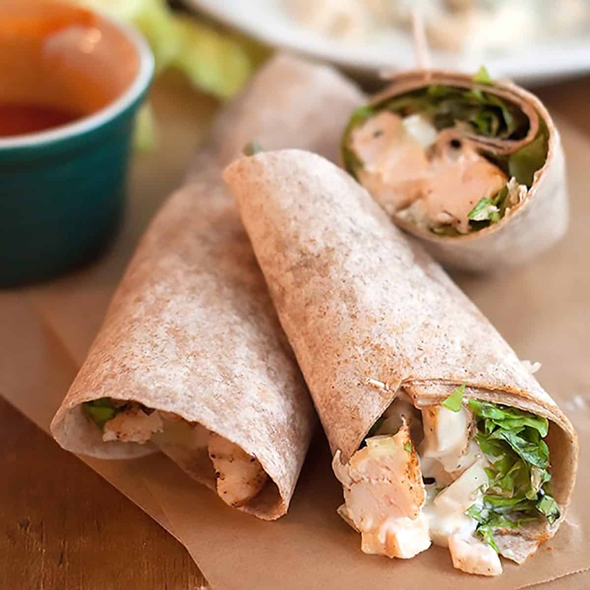 Wraps on brown paper with sauce in the background.