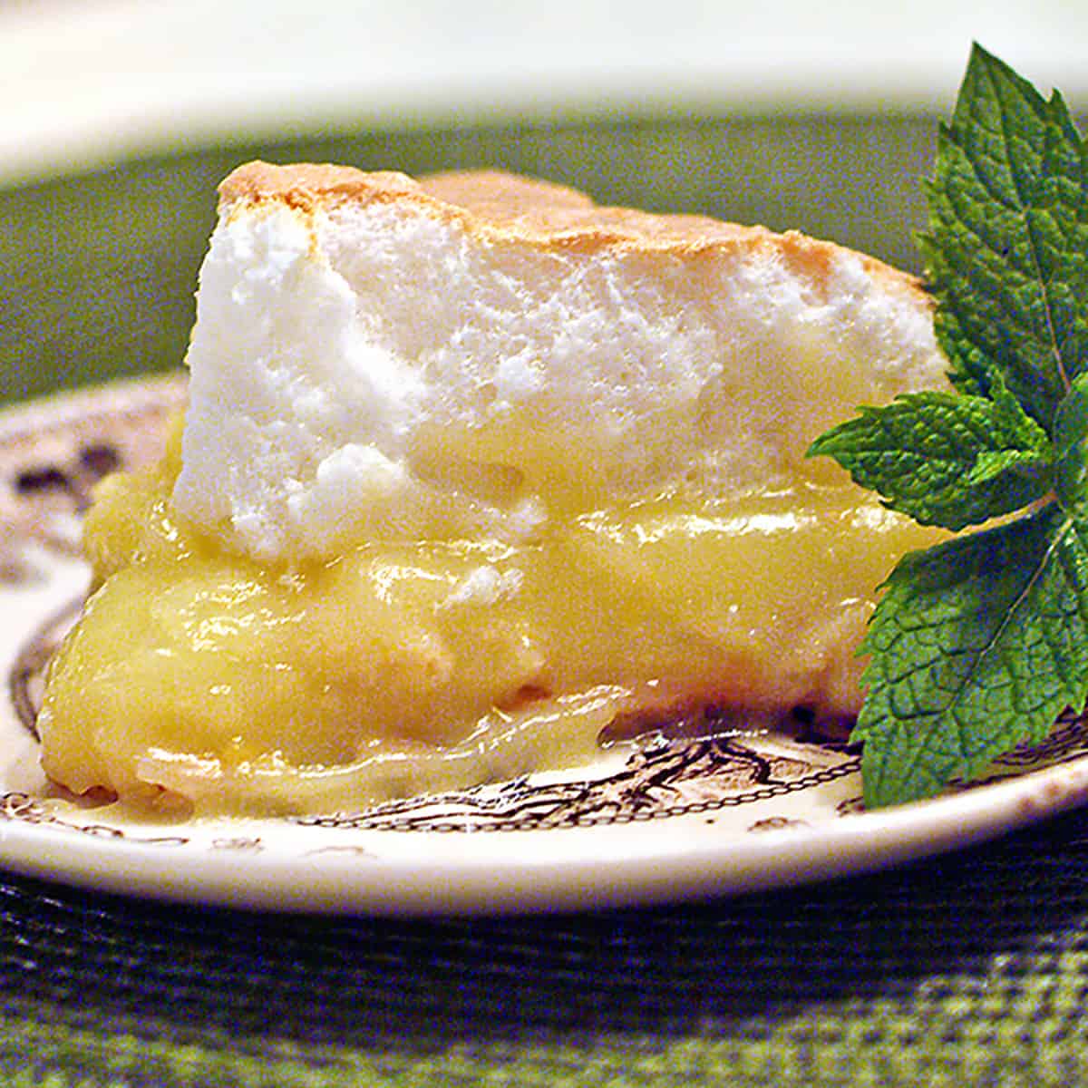 A slice of lemon meringue pie on a dish.