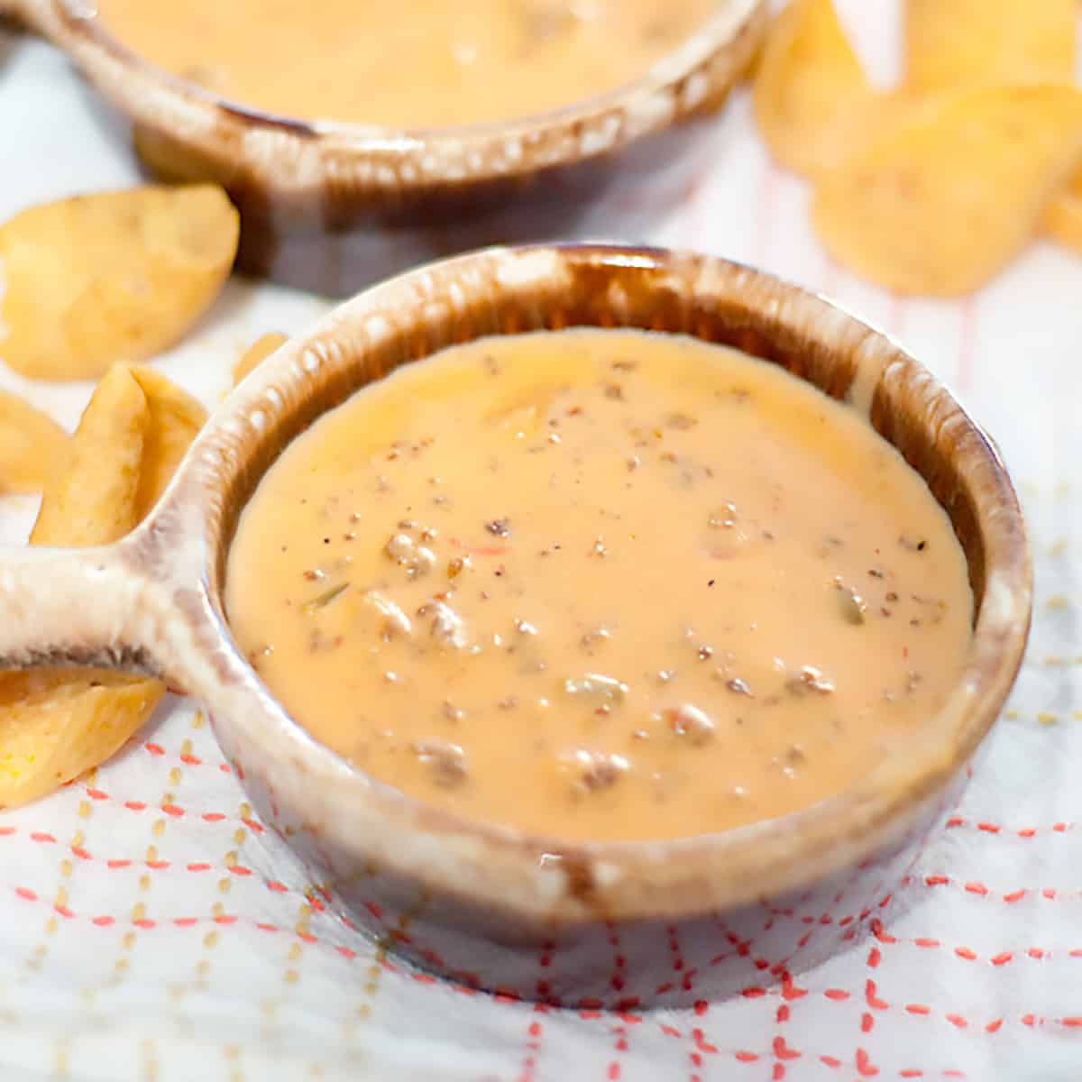 Sausage cheese dip in a small brown bowl.