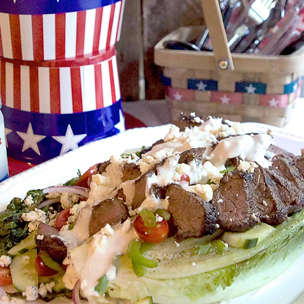 Grilled steak salad on a large white platter.