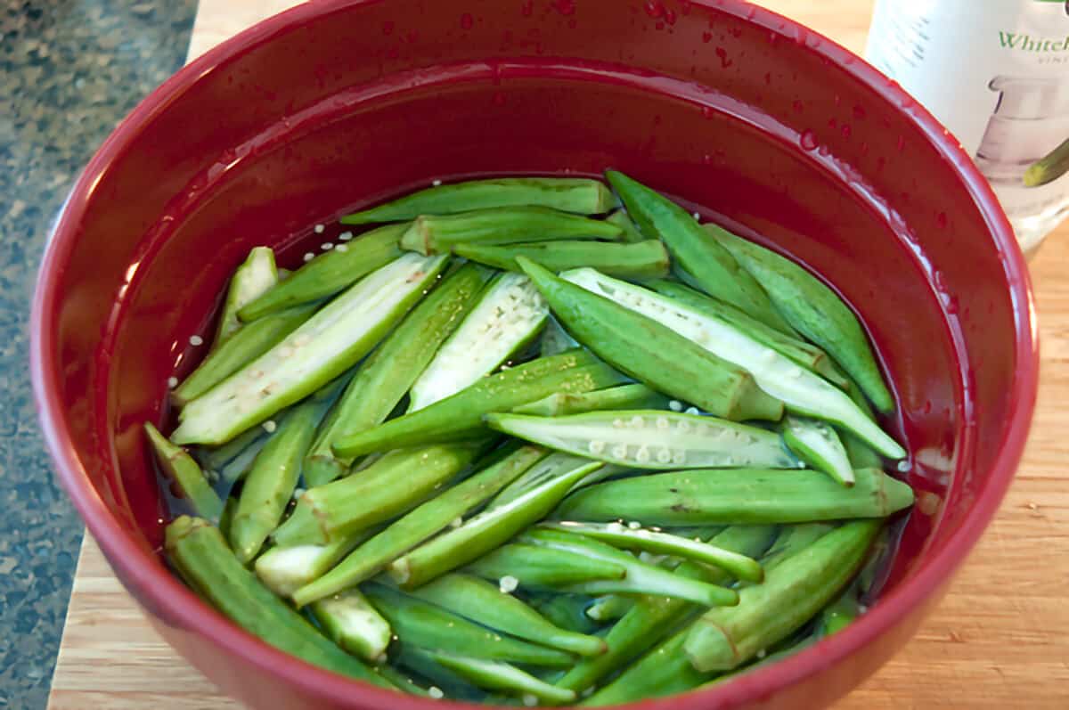 Sliced okra in a red bowl.