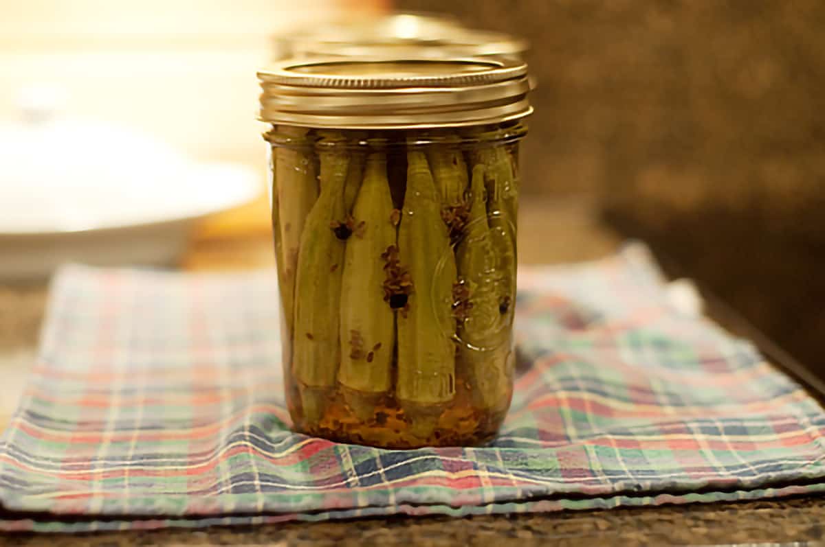 A jar of pickled okra after processing (note color change from bright green to olive green).